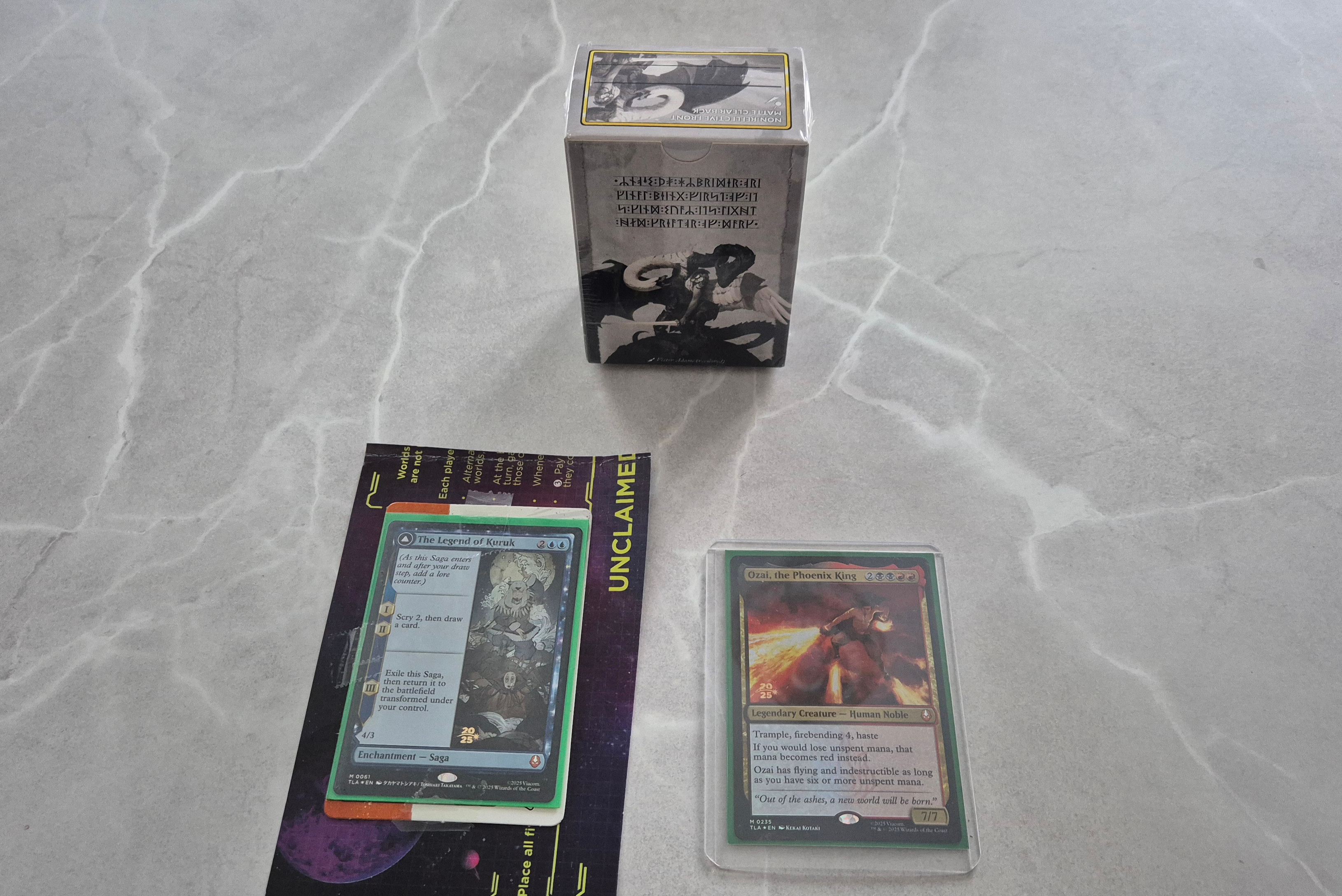 Two prerelease cards and a box of sleeves